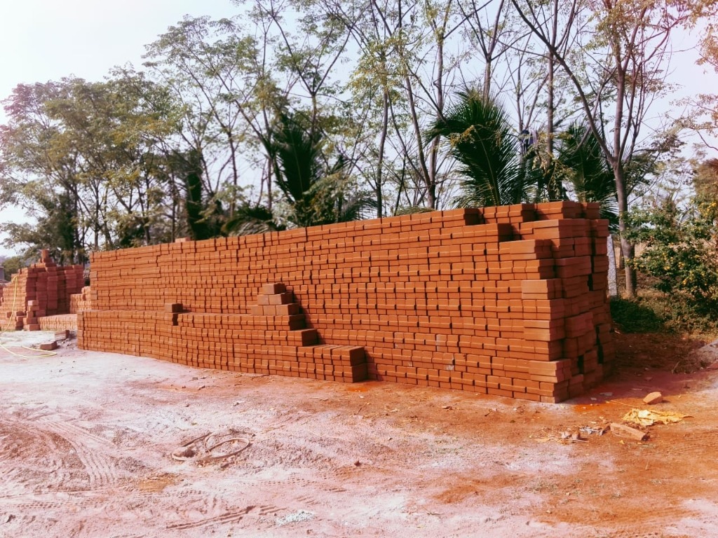 Neatly stacked cured soil mud interlocking blocks in the manufacturing yard of Shree Raam Interlock Bricks